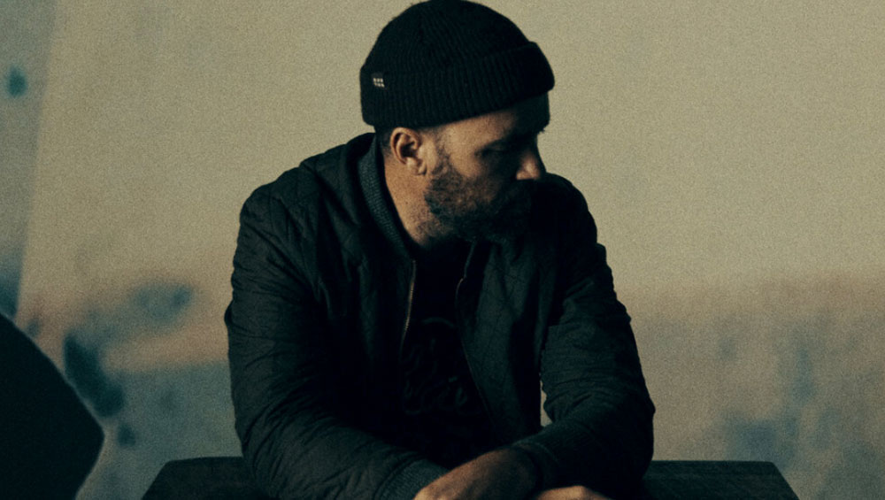A man sits in a moody room